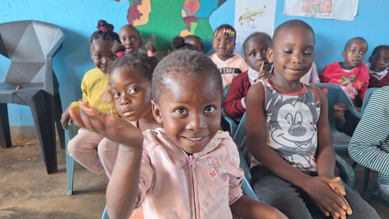 Children smiling and interacting inside a school for orphans run by All Is Grace School in Zambia