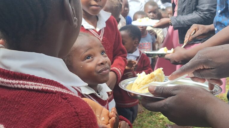 Children at All Is Grace School receive a special treat of birthday cake as part of the school feeding program celebration.